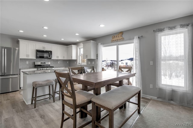 dining area with sink and light hardwood / wood-style floors