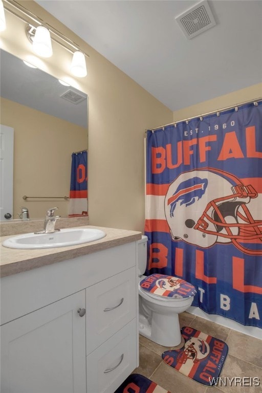 bathroom with tile patterned floors, walk in shower, vanity, and toilet