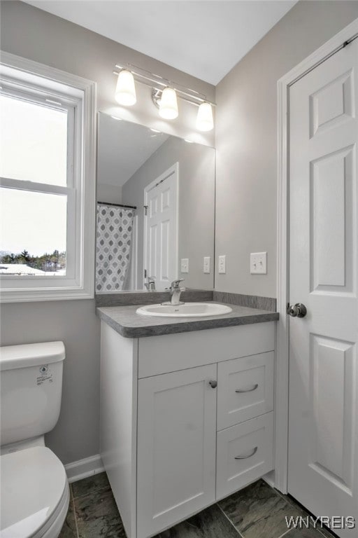 bathroom with vanity, toilet, and curtained shower