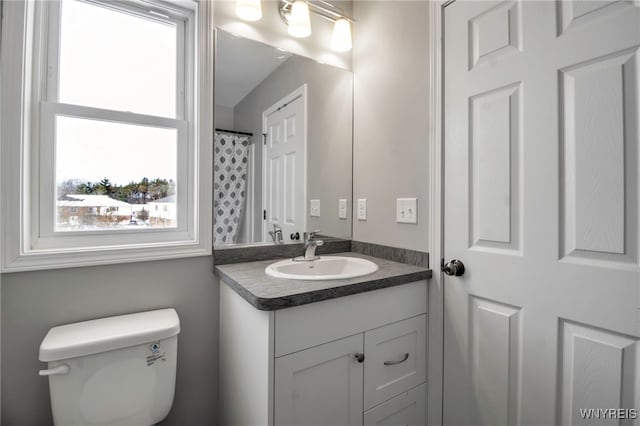 bathroom with vanity, a healthy amount of sunlight, and toilet