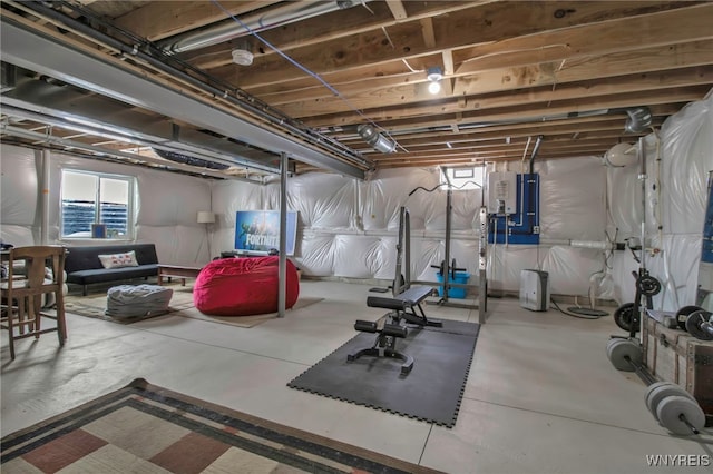 exercise room featuring a healthy amount of sunlight and water heater