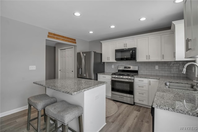 kitchen with a center island, white cabinetry, sink, and appliances with stainless steel finishes