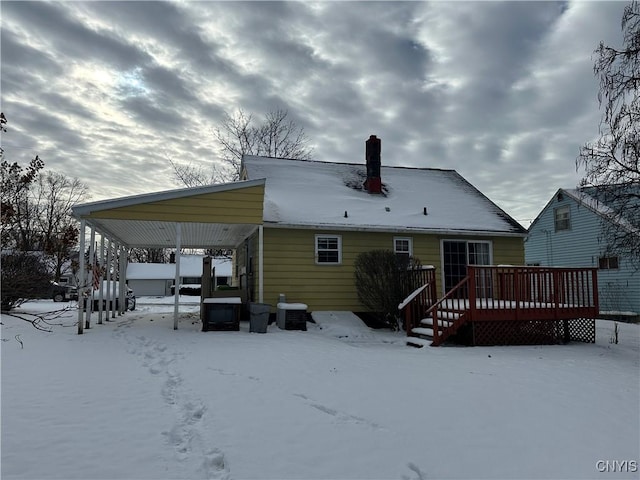 snow covered back of property featuring a deck and cooling unit