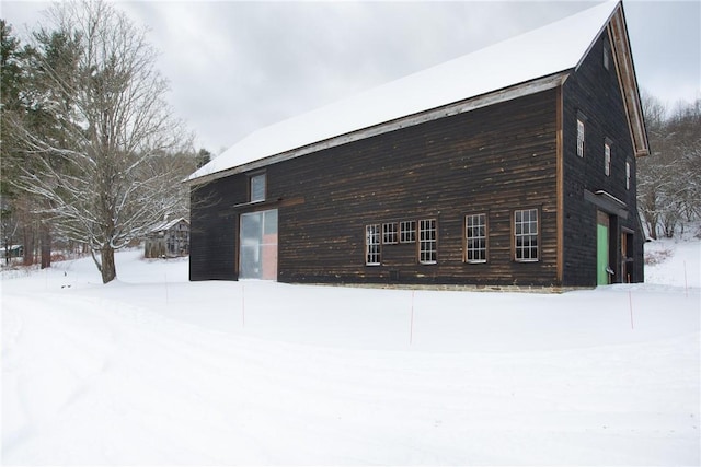 view of snowy exterior featuring a garage