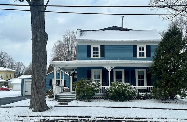 view of front facade featuring covered porch, a garage, and an outdoor structure