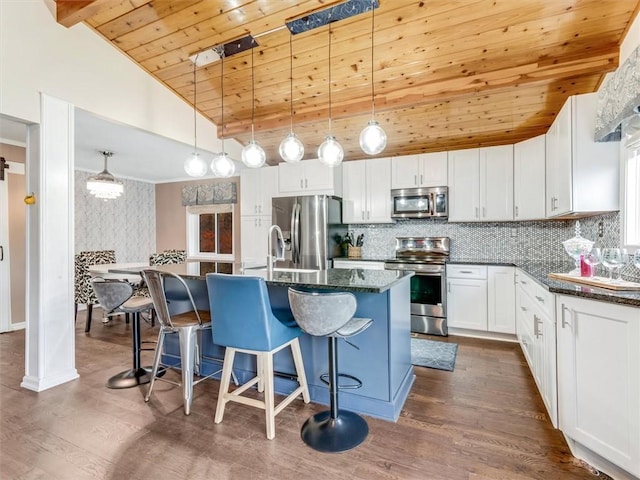 kitchen featuring white cabinetry, decorative light fixtures, decorative backsplash, wood ceiling, and appliances with stainless steel finishes