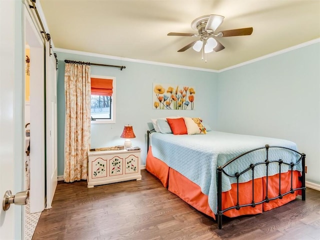 bedroom with a barn door, ceiling fan, wood-type flooring, and ornamental molding