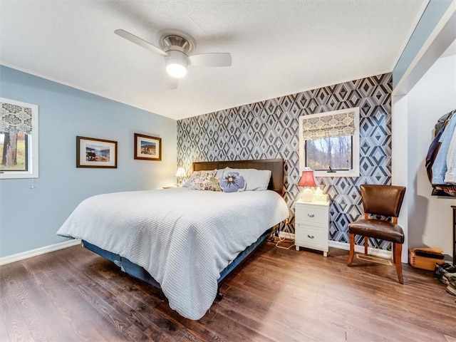 bedroom with multiple windows, ceiling fan, and dark hardwood / wood-style floors