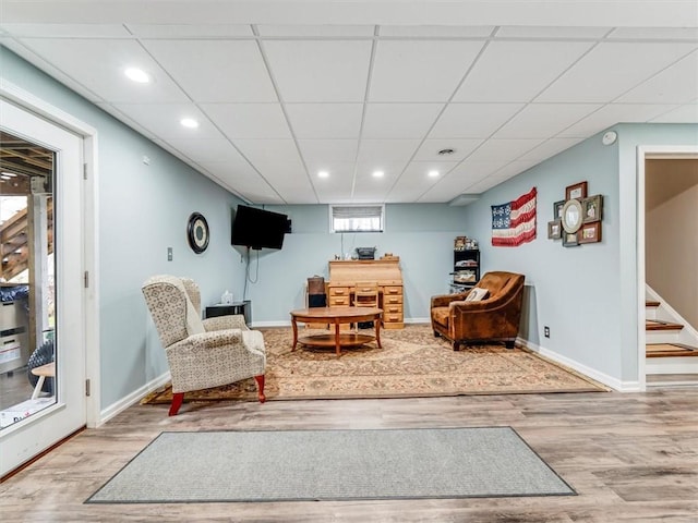 sitting room featuring hardwood / wood-style floors and a drop ceiling