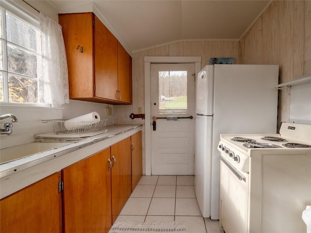 kitchen featuring light tile patterned flooring, sink, a healthy amount of sunlight, and white stove