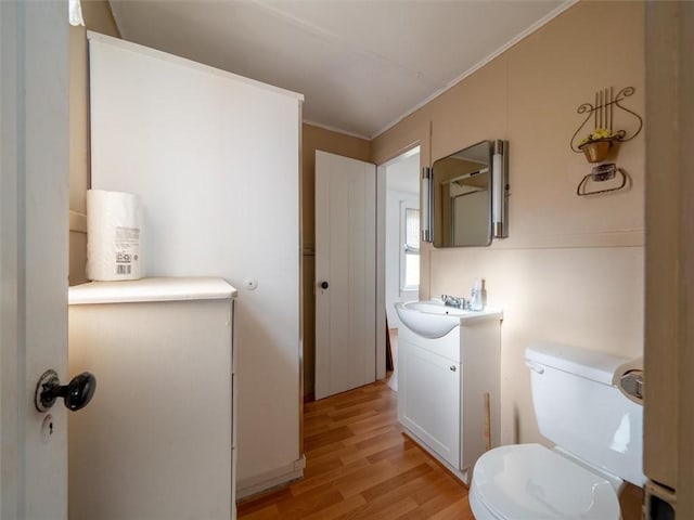 bathroom featuring hardwood / wood-style floors, vanity, toilet, and crown molding