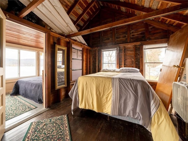 bedroom with wooden walls, vaulted ceiling with beams, dark hardwood / wood-style floors, and wooden ceiling