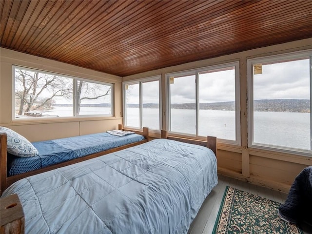 bedroom featuring a water view, wooden ceiling, and wood-type flooring