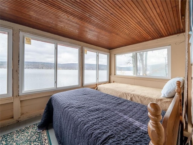 bedroom with a water view and wooden ceiling