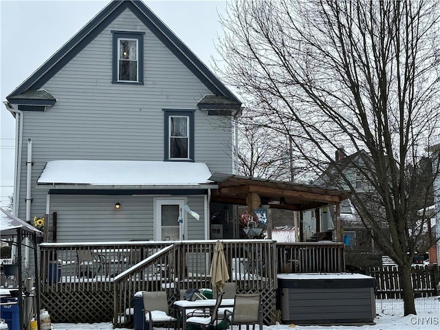 snow covered rear of property with a wooden deck