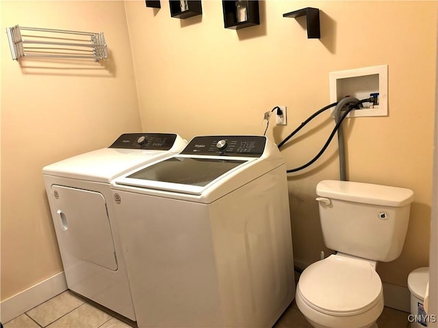 clothes washing area featuring washing machine and dryer and light tile patterned floors