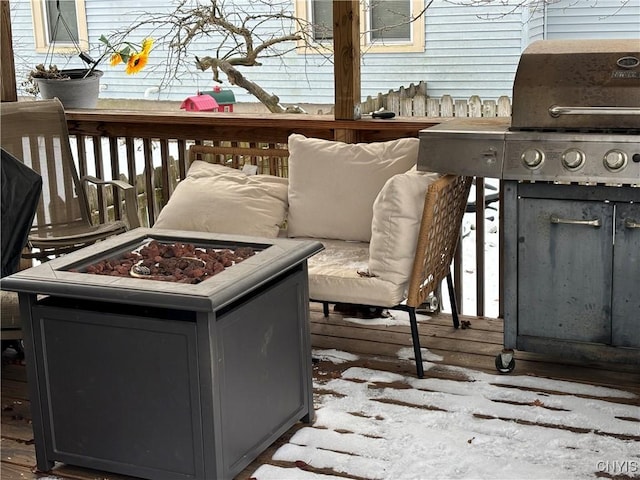 wooden deck featuring a fire pit and a grill