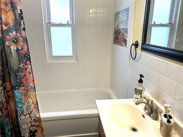 bathroom featuring decorative backsplash, vanity, and tile walls