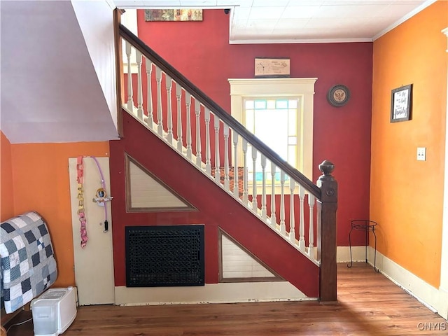 stairway with crown molding and hardwood / wood-style floors