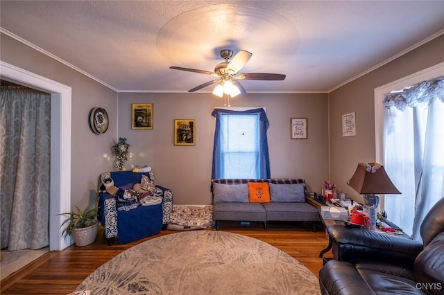 living room featuring hardwood / wood-style flooring, ceiling fan, crown molding, and a wealth of natural light