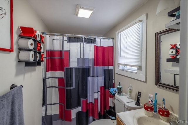 bathroom featuring a shower with shower curtain, vanity, and toilet