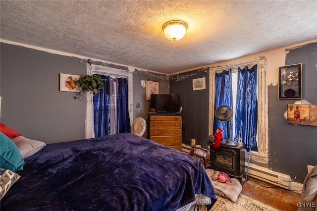 bedroom featuring a wood stove and a textured ceiling