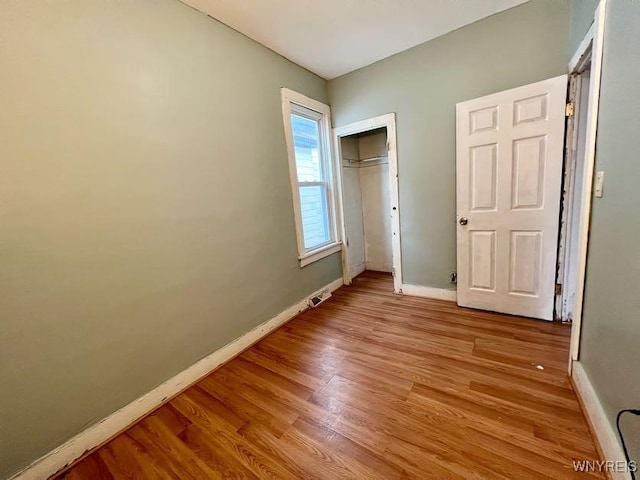 unfurnished bedroom with light hardwood / wood-style flooring and a closet