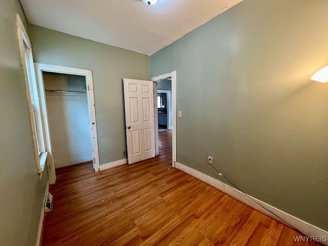 unfurnished bedroom featuring a closet and hardwood / wood-style floors