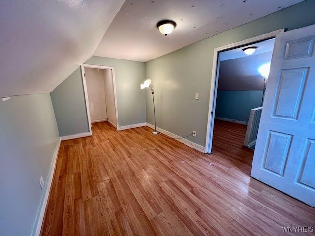 additional living space featuring light hardwood / wood-style floors and lofted ceiling