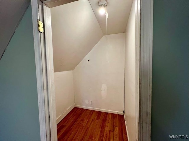 additional living space with dark hardwood / wood-style floors and vaulted ceiling