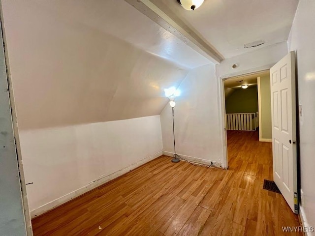 additional living space with light hardwood / wood-style floors and lofted ceiling