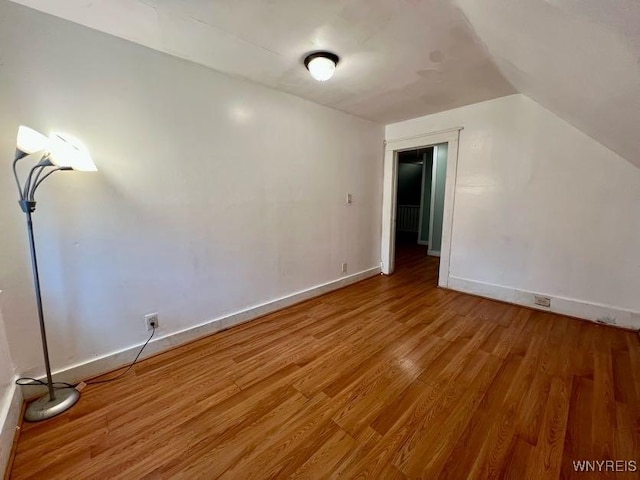 unfurnished room with lofted ceiling and wood-type flooring