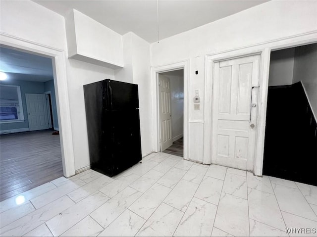 kitchen with black fridge and white cabinets