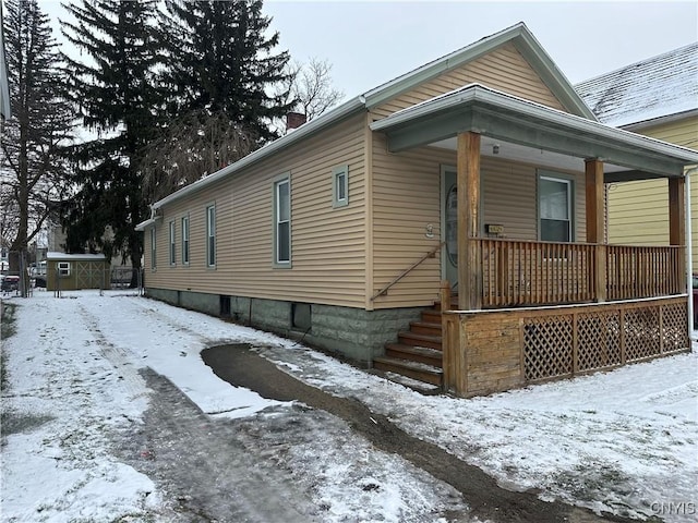 snow covered property with a porch