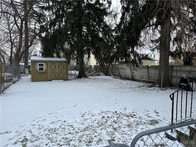 yard covered in snow featuring a storage shed