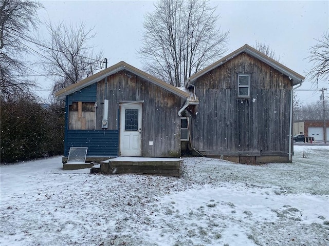 view of snow covered rear of property