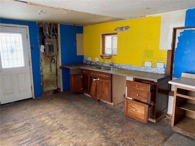 kitchen featuring electric panel, sink, and a textured ceiling