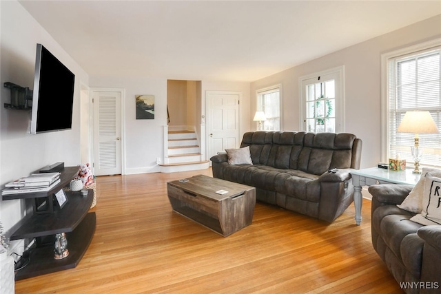 living area with light wood-type flooring and stairs