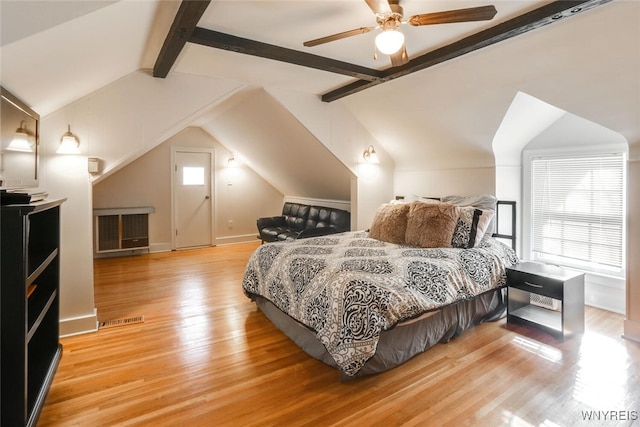 bedroom featuring light wood-type flooring, vaulted ceiling with beams, visible vents, and a ceiling fan