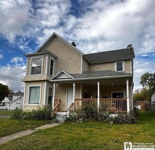 view of front of house with a porch and a front yard