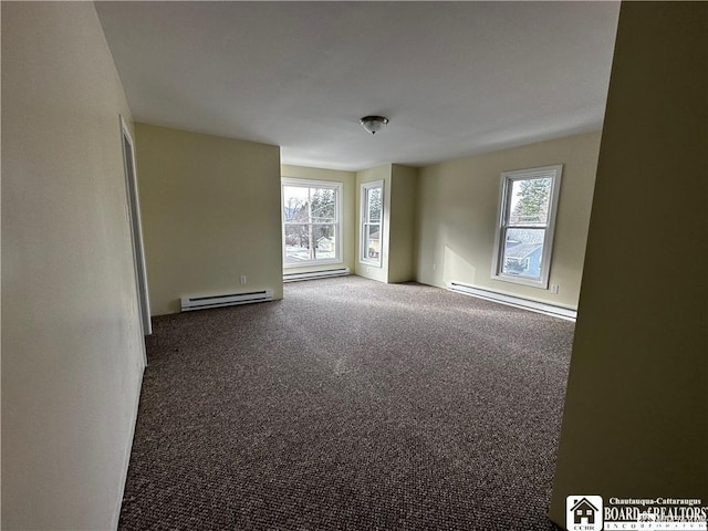 carpeted empty room featuring a healthy amount of sunlight and a baseboard heating unit