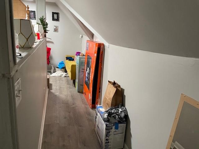 additional living space with dark wood-type flooring and vaulted ceiling