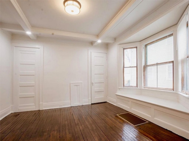 spare room with beam ceiling and dark wood-type flooring