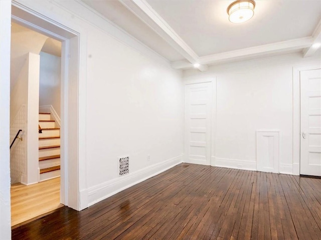 empty room featuring beamed ceiling, dark hardwood / wood-style floors, and ornamental molding