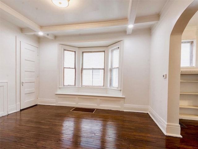 spare room with beamed ceiling and dark hardwood / wood-style floors