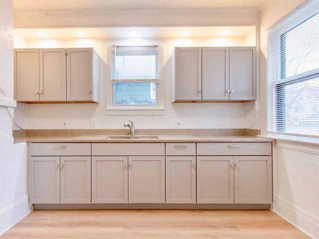 kitchen featuring gray cabinets, sink, and light hardwood / wood-style flooring