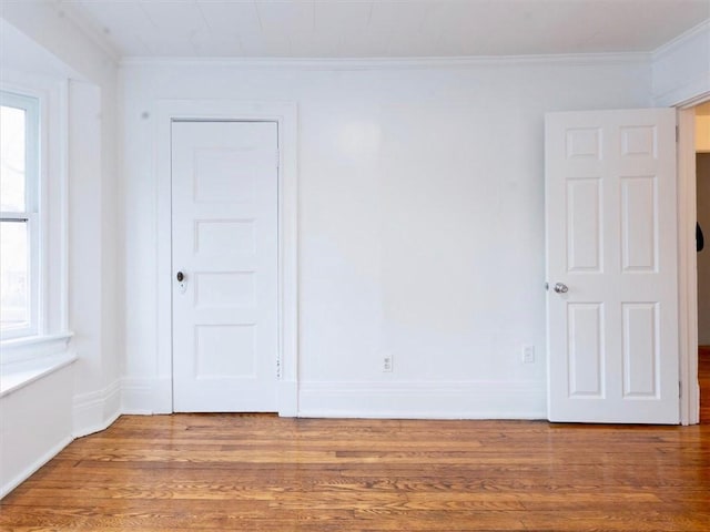 unfurnished room featuring hardwood / wood-style flooring and ornamental molding