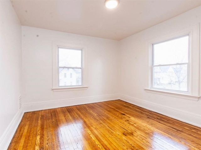 empty room with hardwood / wood-style floors and a wealth of natural light