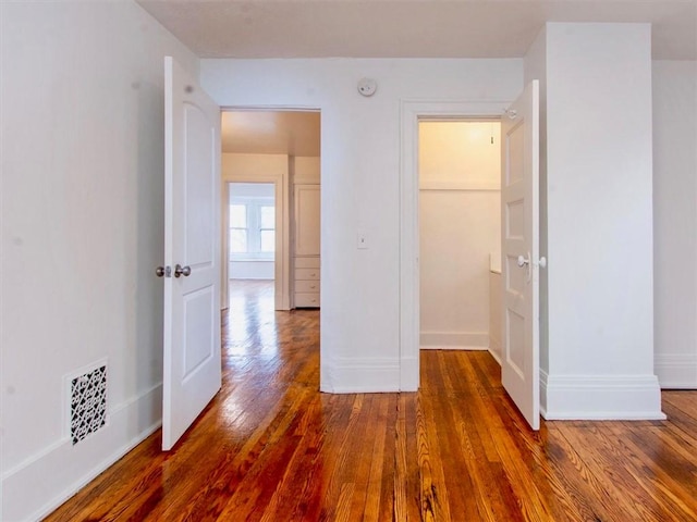 unfurnished bedroom featuring a closet and dark hardwood / wood-style floors