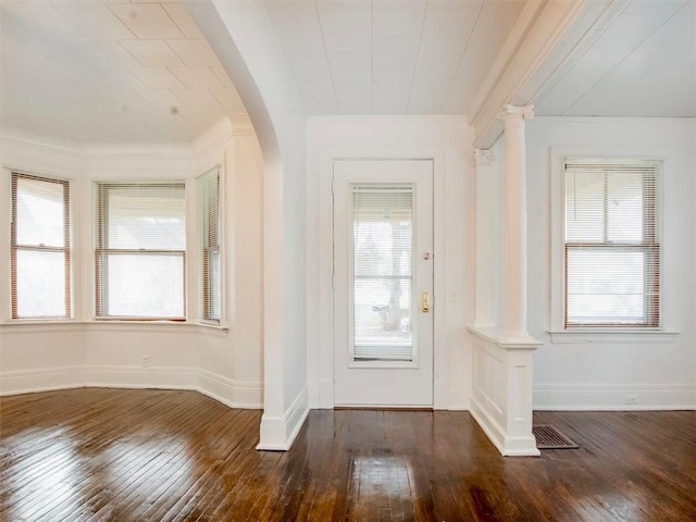 entryway with decorative columns and dark wood-type flooring